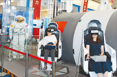 圖為參觀者通過VR（虛擬現實）設備體驗宇航員出艙的過程。